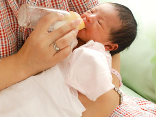 哺乳瓶で赤ちゃんにミルクを飲ませる