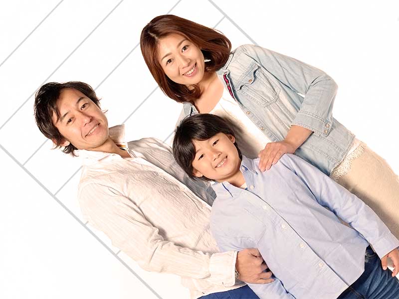 両親と背比べをしている男の子