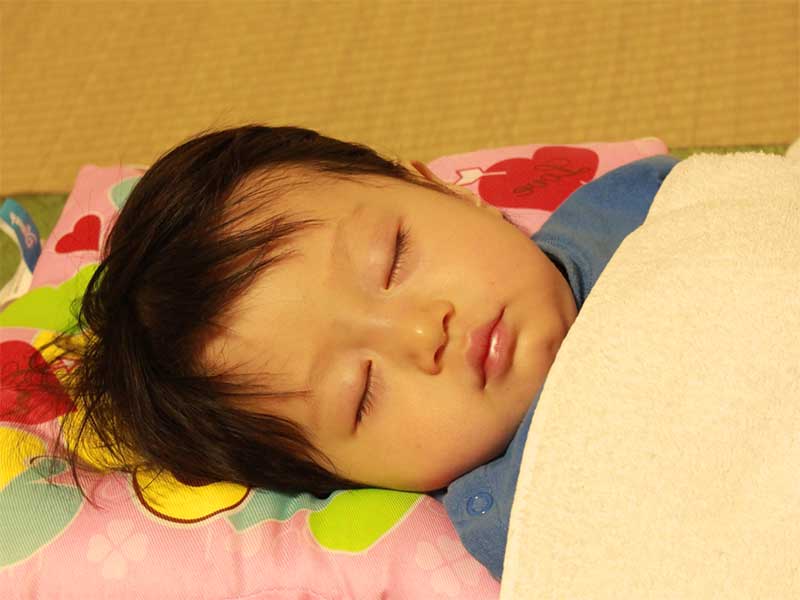 布団でぐっすり寝ている子供