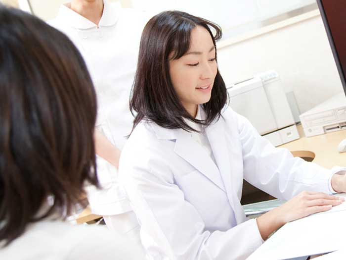 女医の診断を受ける妊婦
