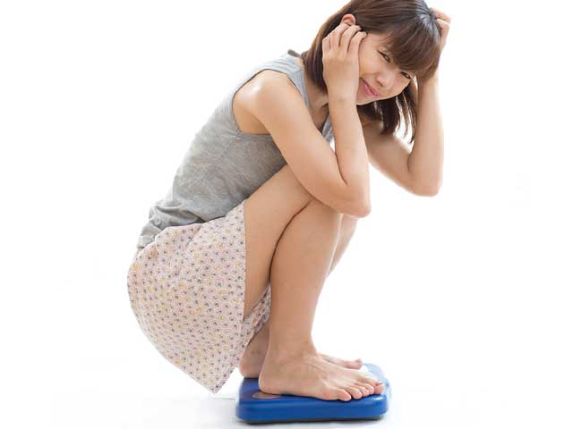 体重計に載る女性