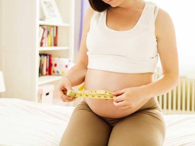 お腹周りを測る妊婦