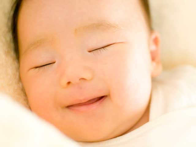 寝ながら微笑む赤ちゃん
