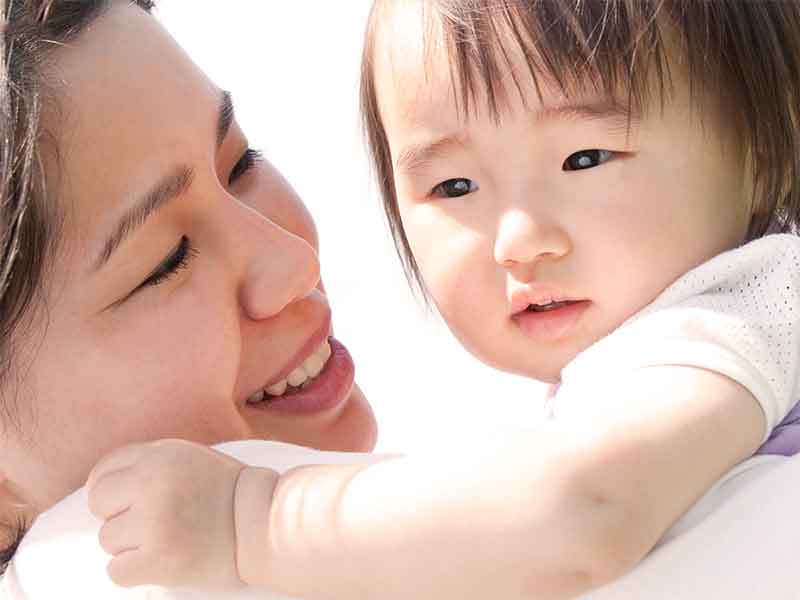 赤ちゃんに顔を近づける母親