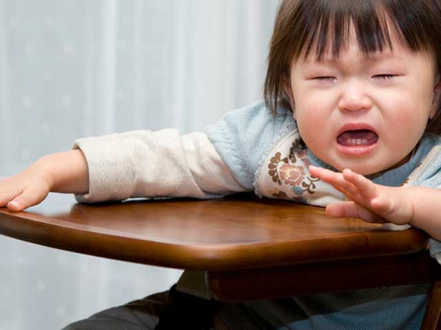 椅子に座りながら泣く幼児