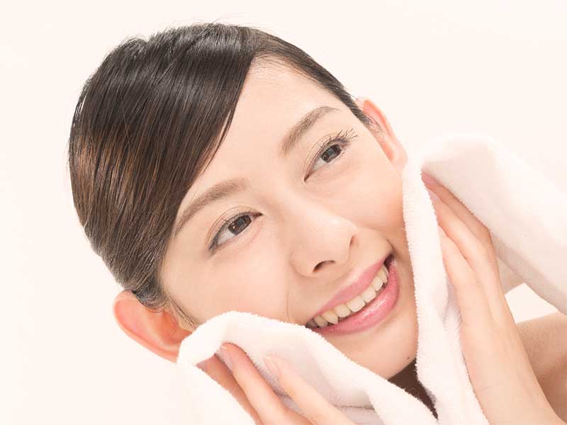 蒸しタオルヲ顔にあてている女性
