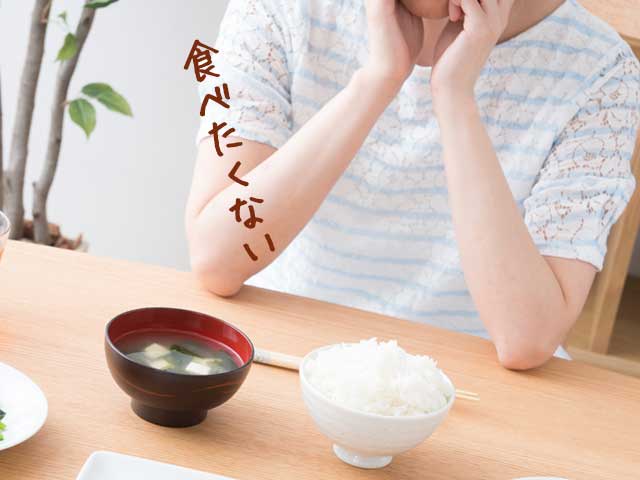 食事を前に頬杖をつく女性