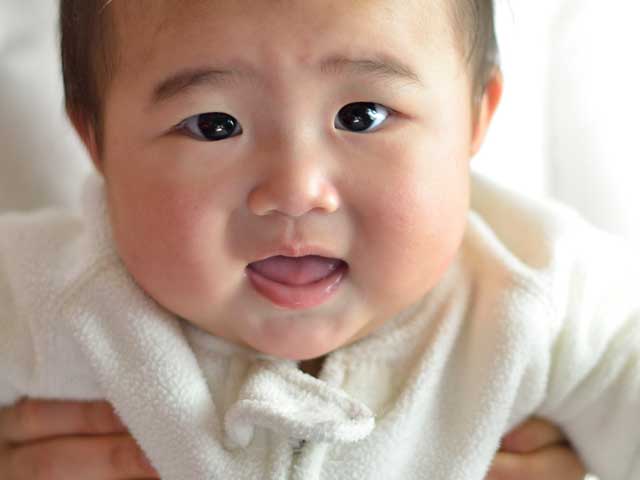 抱き上げられた新生児