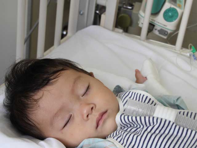 病院のベッドで眠る幼児