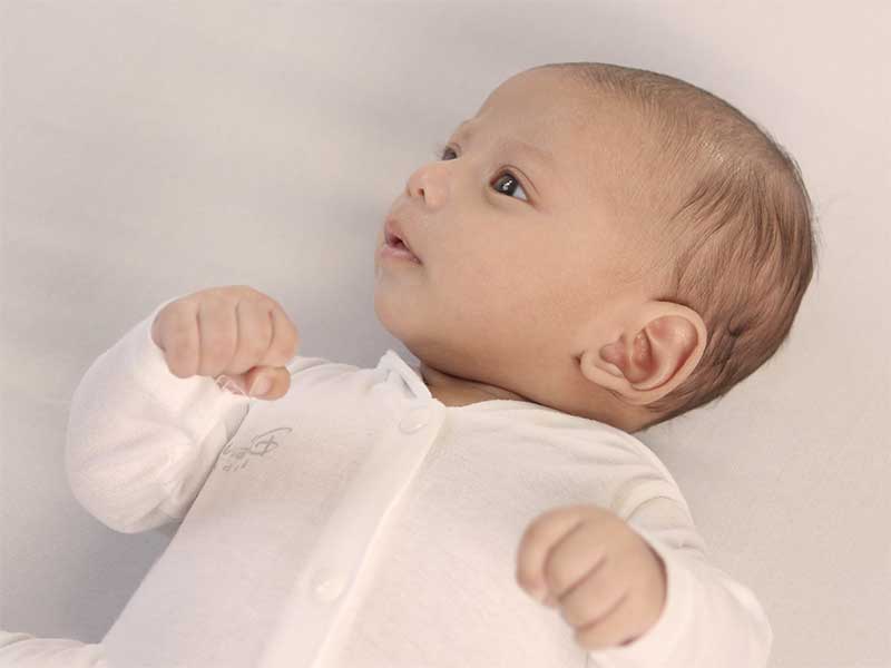 肌着のみで笑顔の新生児