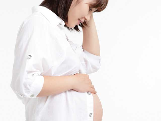 自分のお腹を見る妊婦