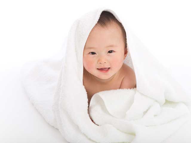 タオルにくるまる裸の赤ちゃん