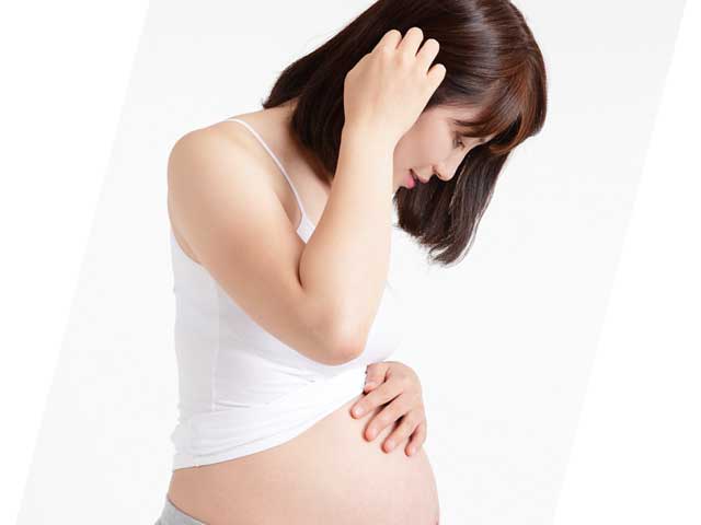 自分のお腹を見る妊婦