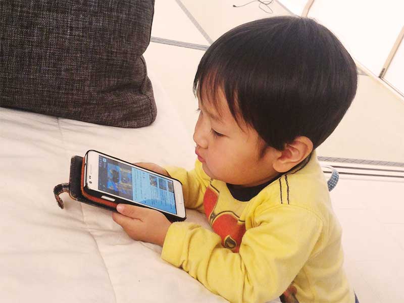 スマホでゲームをしている男の子