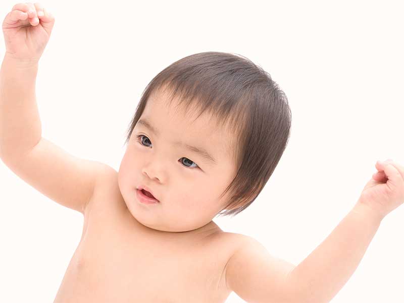 チーズを食べて元気になってガッツポーズをしてる赤ちゃん