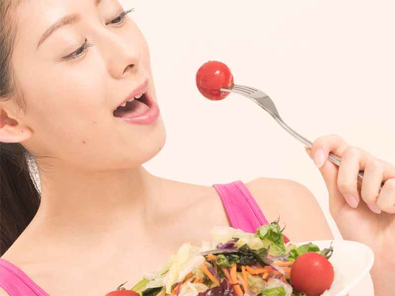 トマトを食べている女性