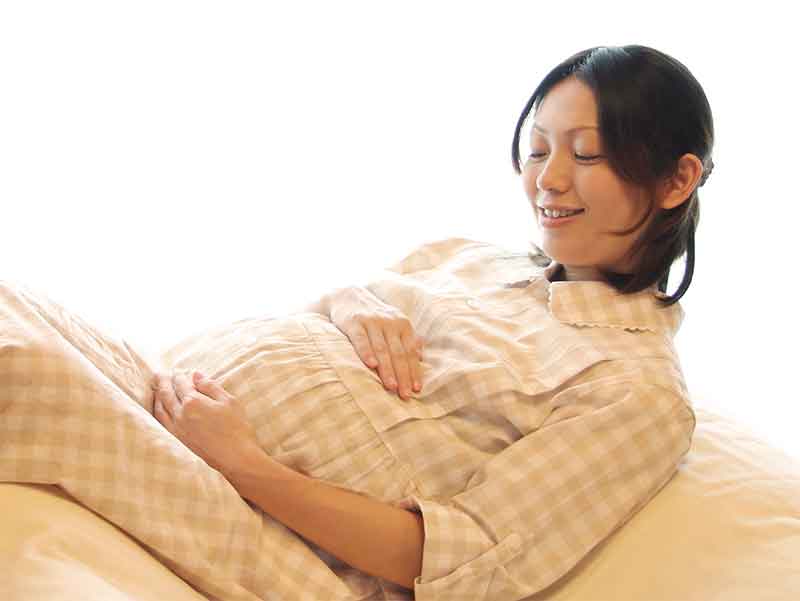 お腹をなでている妊婦さん