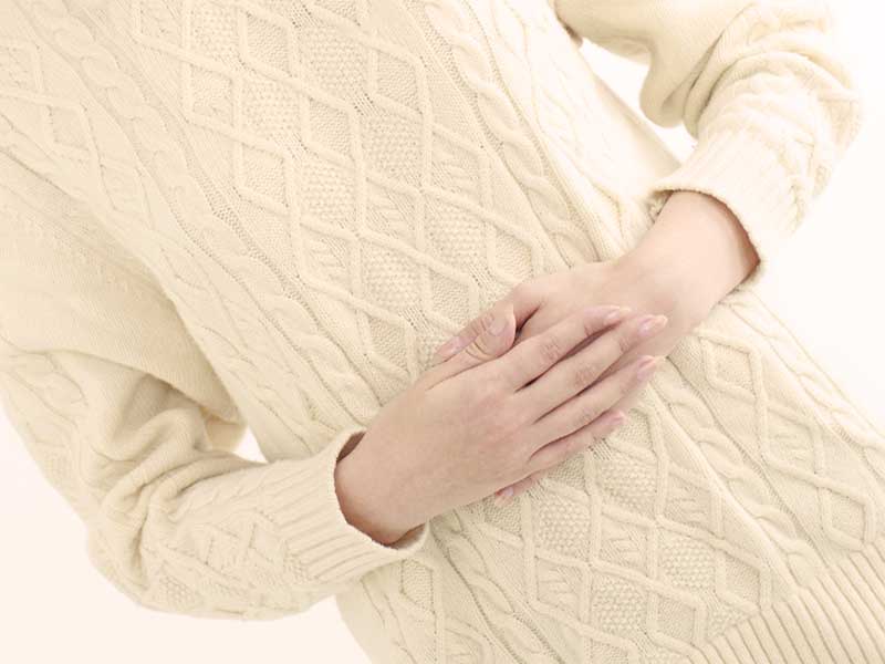 後陣痛でお腹を押さえている女性