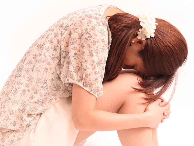 膝をかかえて落ち込んでいるママ