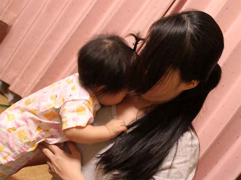 落ち込みつつも子供を抱き寄せてる母親