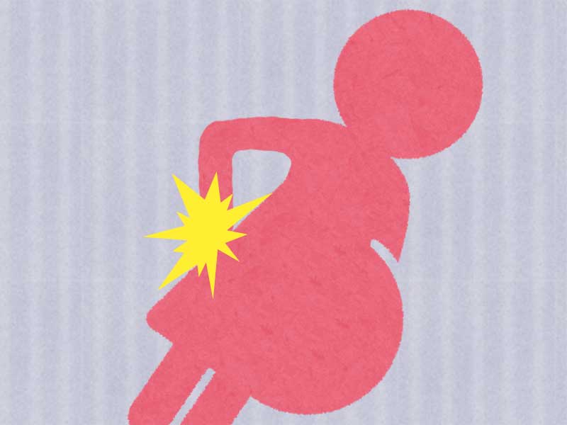 腰を痛めている妊婦のシルエット