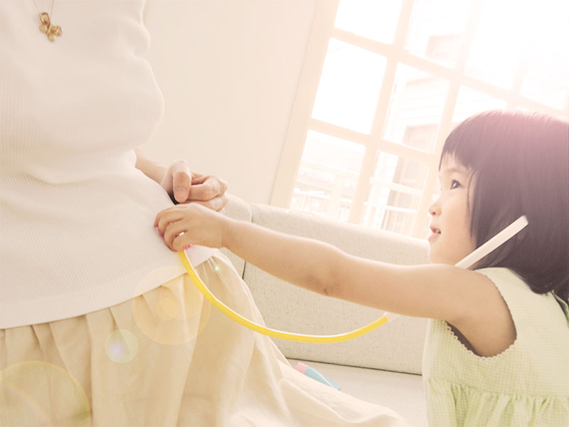 部屋で子供と一緒に休んでいる妊婦