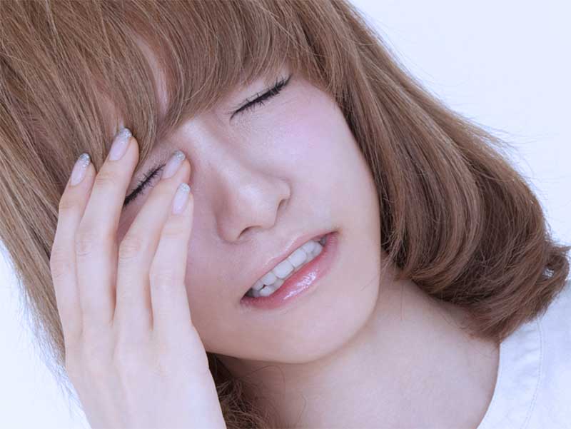 偏頭痛でこめかみを手で抑える嫁