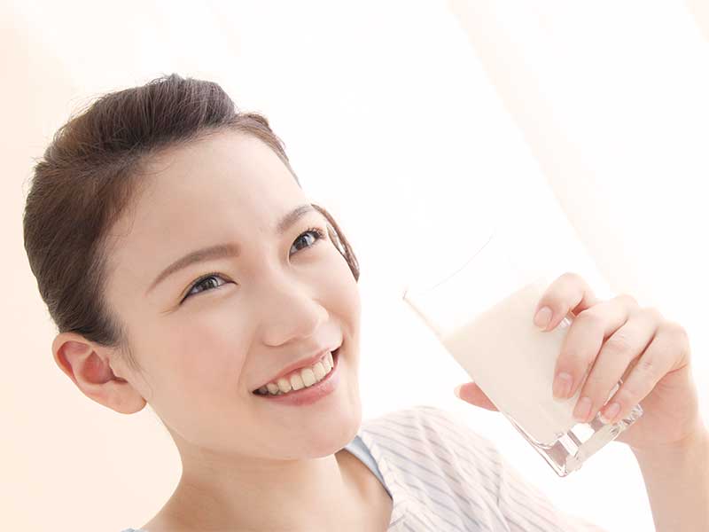 笑顔で牛乳を飲んでる女性