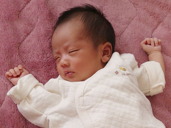 手を広げて寝てる赤ちゃん