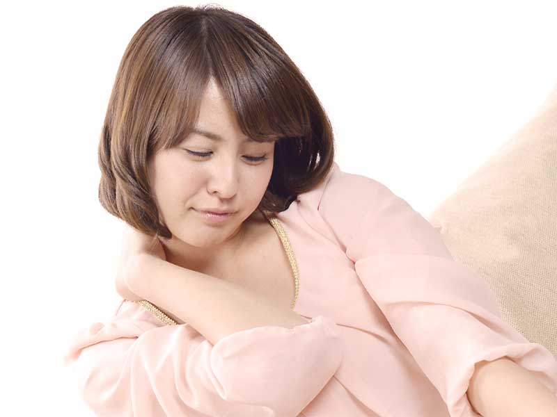 肩こりが痛く肩を押さえているママ