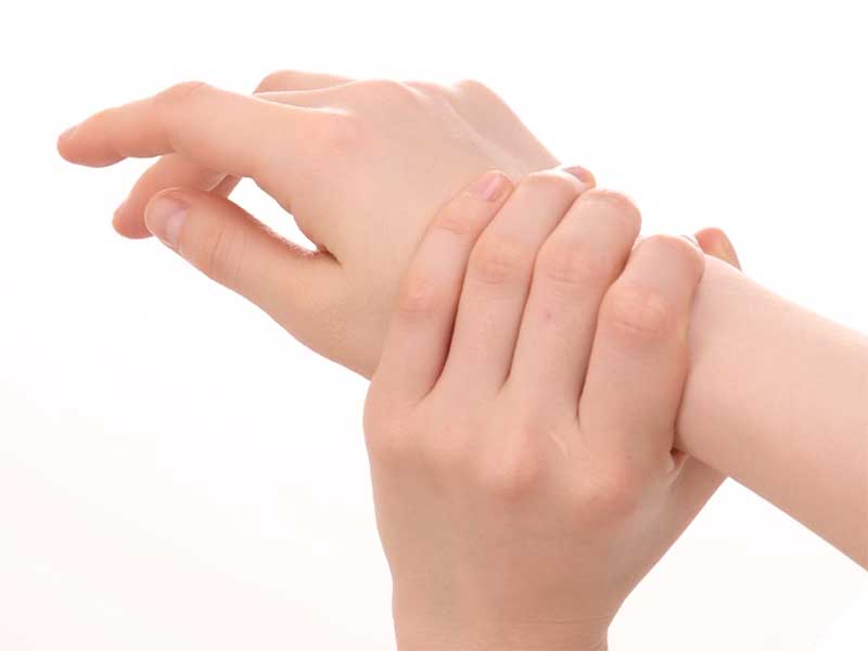 腱鞘炎の痛みで手首を押さえてる女性