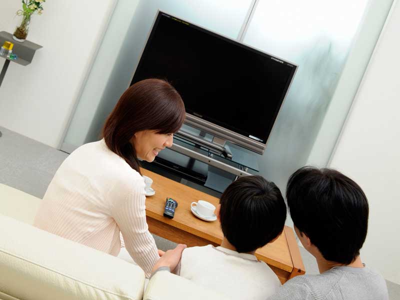 明るい部屋でテレビを見ている家族