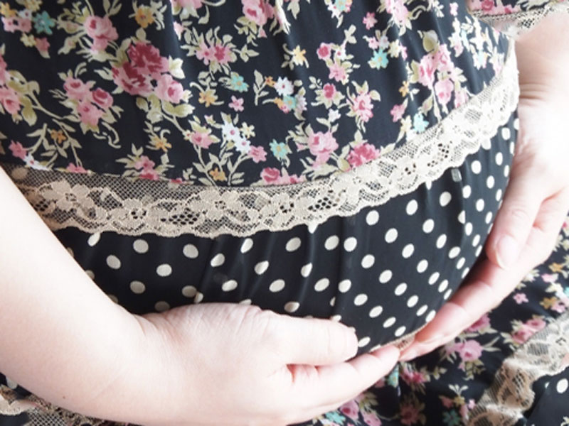 妊婦さんが自分のお腹を触っている