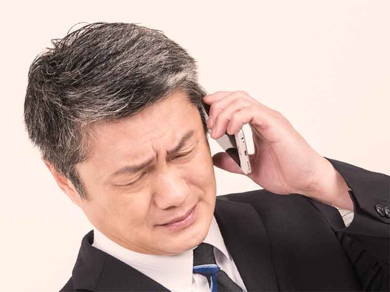 仕事の電話でストレスを感じてる男性