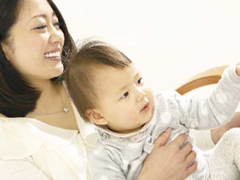 椅子に座っているお母さんが赤ちゃんを抱っこしてる