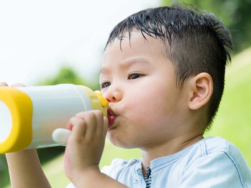 汗をかいた男の子がドリンクを飲んでいる