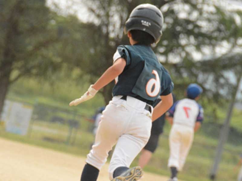 走っている野球少年