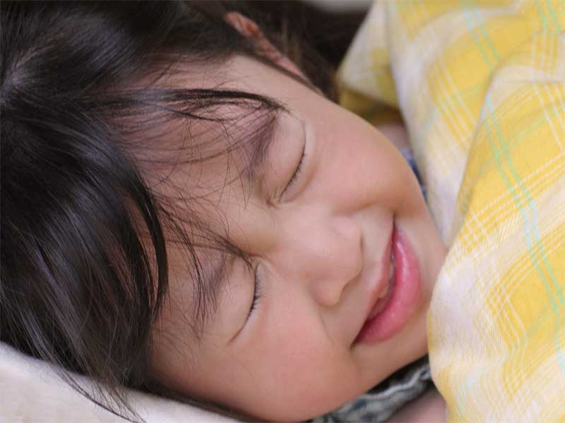 耳下腺の痛みを我慢して布団に入ってる女の子の顔