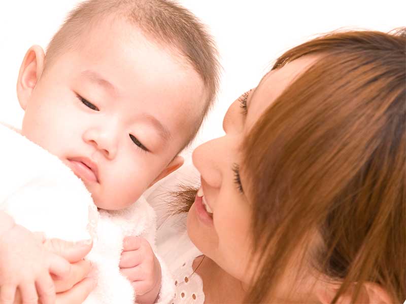 抱っこしてる赤ちゃんの顔を見てるママ