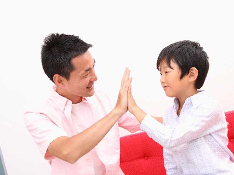 子供とハイタッチするお父さん