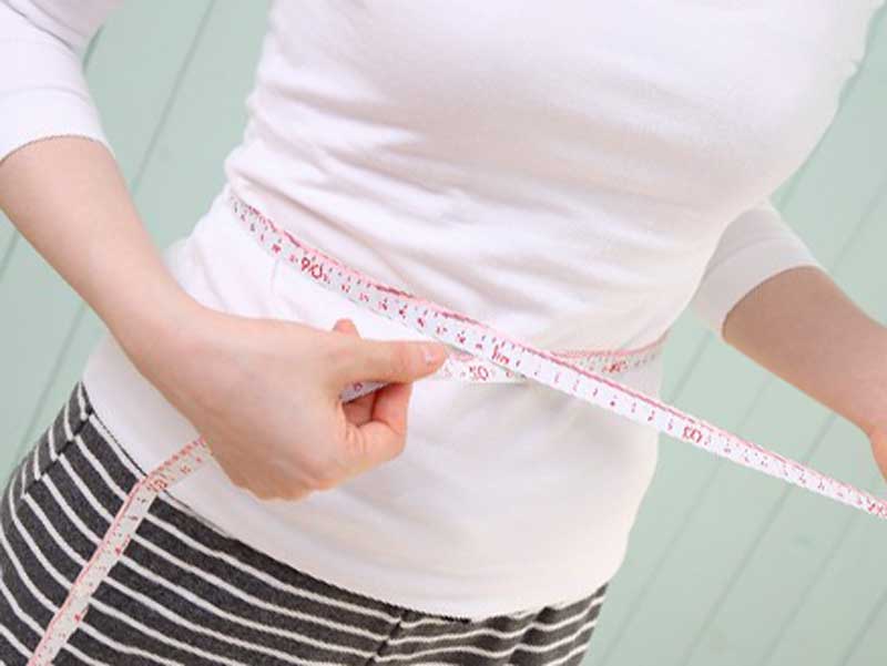ダイエットしてウエストのサイズを測ってる女性