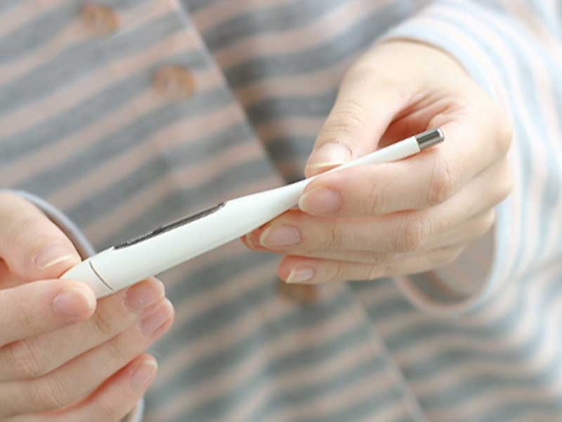 体温計を持つ女性