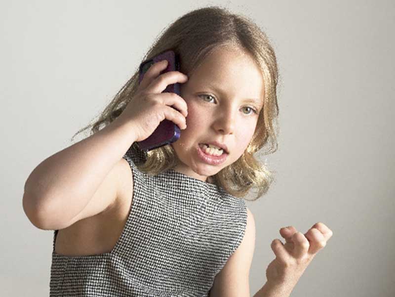 電話で怒りながら話している子供