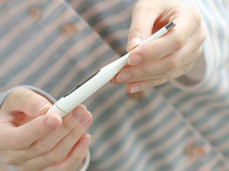 体温計を持つ女性