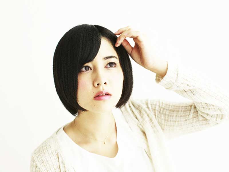 髪の毛を気にしている女性