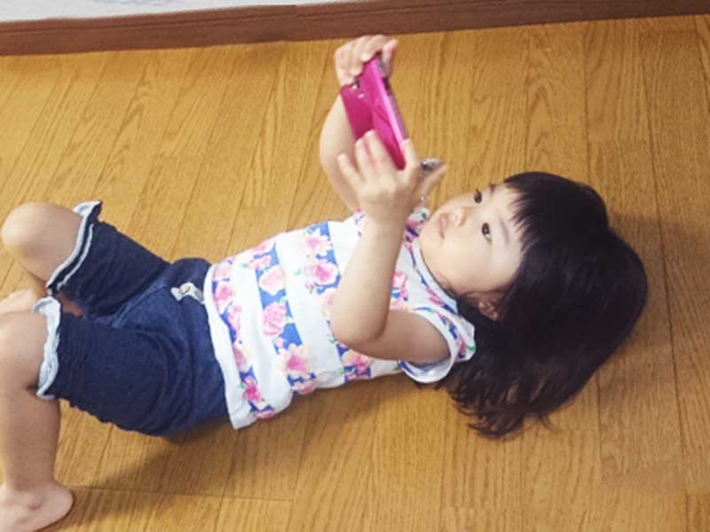 スマホでゲームをする子供