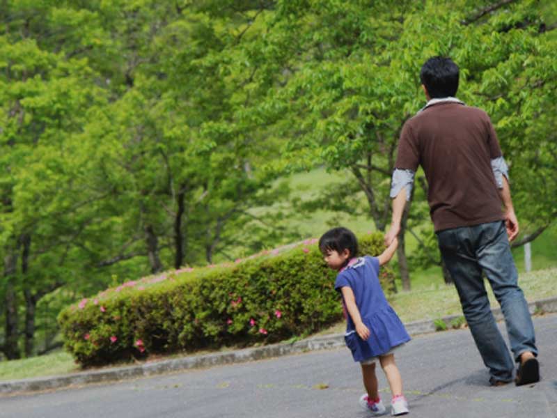 子供を連れて散歩するお父さん