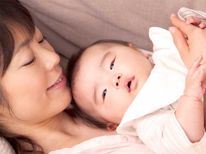 新生児を抱っこしているママ