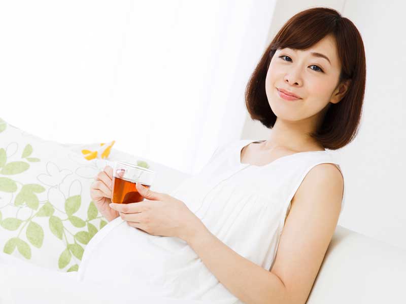 ソファの上に座る出産直前の妊婦