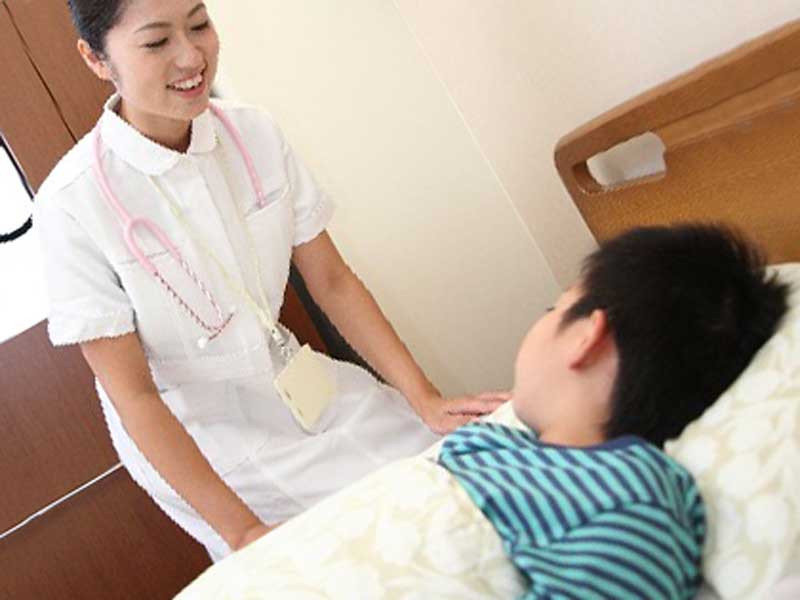 入院している男の子と看護師